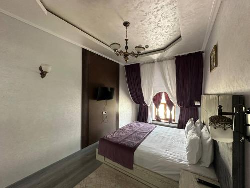 a bedroom with a large bed and a window at GRAND SARBON HOTEL in Qarshi