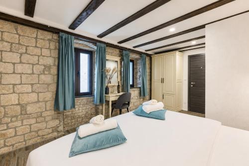 two beds in a room with blue curtains at Split Old Town Rooms Matushko in Split