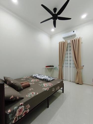 a bedroom with a bed and a ceiling fan at Private Pool Homestay Kota Bharu 3 Bilik Tidur Muat 12 Tetamu in Kota Bharu