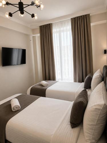 a hotel room with two beds and a television at Urban Hotel in Bishkek
