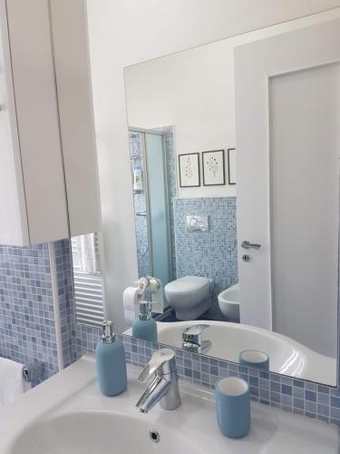 a bathroom with a sink and a toilet and a mirror at Il Cuore di Santa è tutto blu in Santa Margherita Ligure