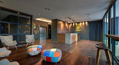 a lobby with chairs and a bar in a building at U Hotel Penang in Bayan Lepas