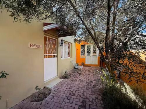 a house with an orange door and a brick walkway at The Rose and Olive in Cradock