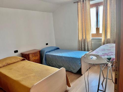 a small bedroom with two beds and a window at La villetta di Lilly in Predaia