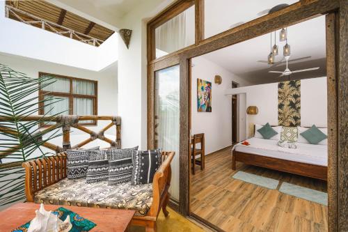 a living room with a bed and a mirror at Haber Hotel & SPA in Matemwe