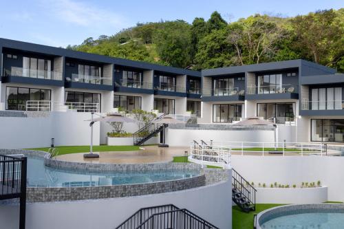 an exterior view of a building with two pools at Elite Suites Villas Maikhao Phuket in Mai Khao Beach