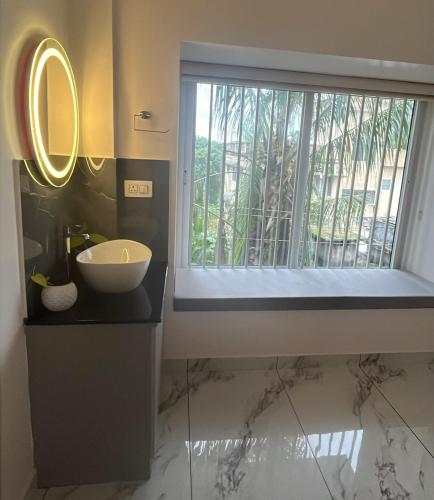 a bathroom with a sink and a window at Malhar Homes in Kozhikode