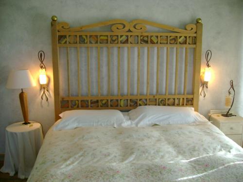 ヴィテルボにあるLa Paloma B&B di Charmeのベッドルーム1室(大型ベッド1台、木製ヘッドボード付)