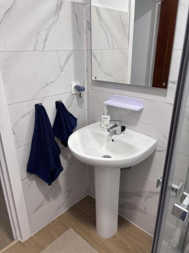 a white bathroom with a sink and a mirror at Casa La Peña in Luarca