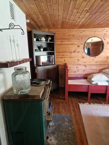 a kitchen with a stove and a bed in a room at Cute old garden cottage in Kirkkonummi