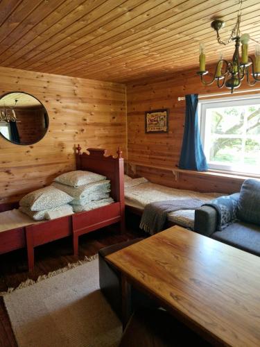a room with two beds in a log cabin at Cute old garden cottage in Kirkkonummi