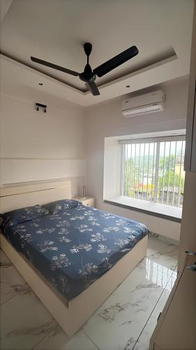 a bedroom with a bed and a ceiling fan at Malhar Homes in Kozhikode