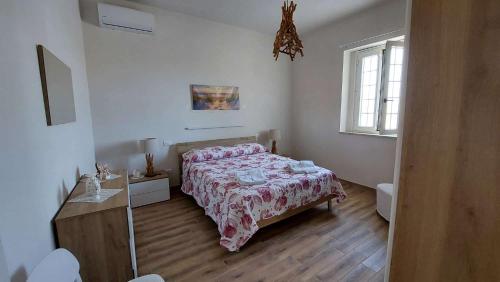 a bedroom with a bed and a wooden floor at Villetta della Pace nel cuore del Salento in Torre Santa Susanna