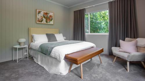 a bedroom with a bed and a chair and a window at Three Oaks in Red Hill