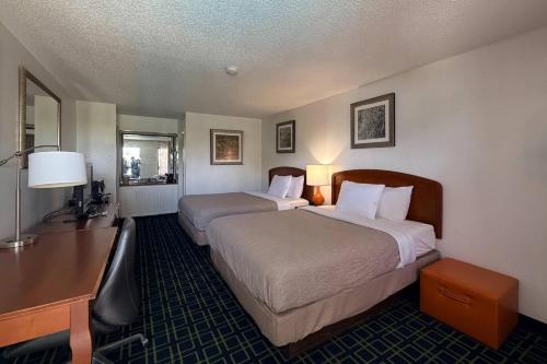 a hotel room with two beds and a desk at Quality Inn At the Mall - Valdosta in Valdosta