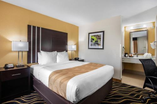 a hotel room with a large bed and a desk at Quality Inn West Fort Worth in Fort Worth