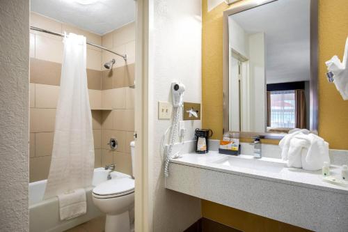 a bathroom with a sink and a toilet and a mirror at Quality Inn West Fort Worth in Fort Worth