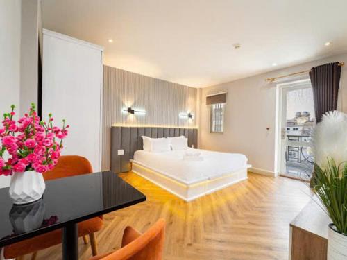 a bedroom with a bed and a table with flowers at Golden Suites Saigon in Ho Chi Minh City
