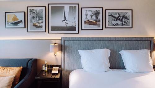 a hotel room with a bed and framed pictures on the wall at Columbus Hotel Monte-Carlo, Curio Collection by Hilton in Monte Carlo