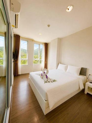 a bedroom with a large white bed with white pillows at Courtyard khaoyai by August in Khao Yai