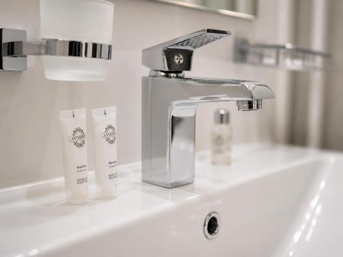a sink with a faucet on a white counter at Urban Hotel in Bishkek