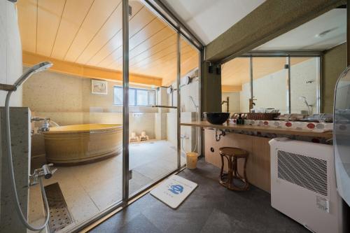 a bathroom with a large tub and a sink at 江ノ島の島内で一棟貸し一日一組限定はまさき旅館 in Fujisawa