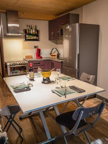 a kitchen with a white table with chairs and a refrigerator at Ski Chalet located Meribell in Les Allues