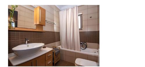 ein Badezimmer mit Waschbecken, Toilette und Badewanne in der Unterkunft Jack Villa's in Chavgas