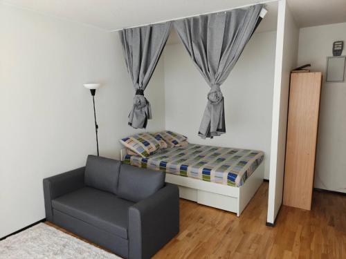 a small bedroom with a bed and a chair at Sunny 4th-Floor Park-View Studio Escape in Turku