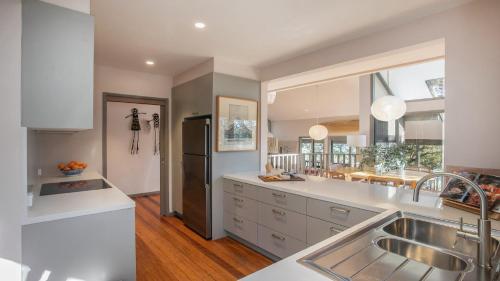 a kitchen with white counters and a large window at Coastal Wilderness Retreat in Hardys Bay