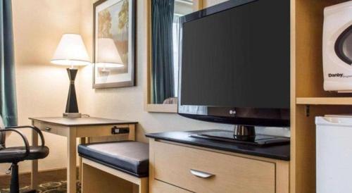 a hotel room with a flat screen tv on a dresser at Quality Inn Geneseo in Geneseo