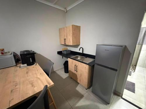 a small kitchen with a wooden table and a refrigerator at Green Haven 2 in Tzaneen