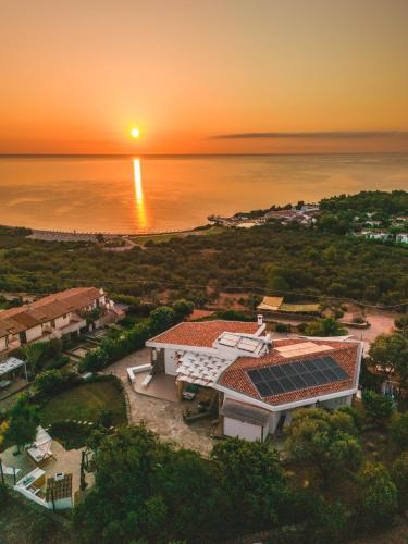 an aerial view of a house with solar panels on the ocean at Amoreddu in San Teodoro