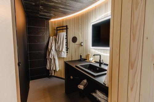 a bathroom with a sink and a television in it at Livo Arctic Resort in Posio