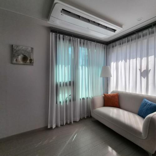 a living room with a couch and a large window at YYStay 감성 루프탑 in Seoul