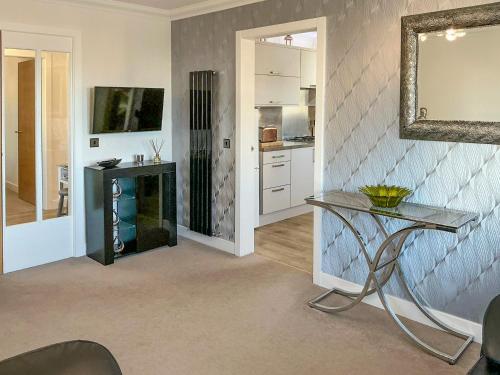 a kitchen with a glass table and a mirror at Serenity in Cellardyke