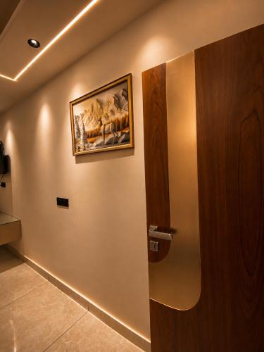 a door in a room with a painting on the wall at Panipat Prime in Pānīpat