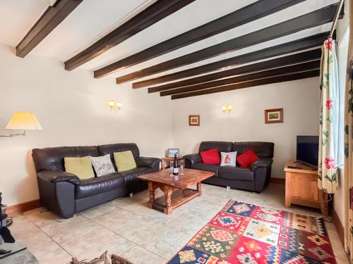 a living room with two leather couches and a table at Windy Ridge Low Row in Feetham