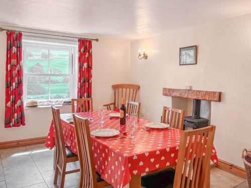 a dining room with a table with a red polka dot table cloth at Windy Ridge Low Row in Feetham