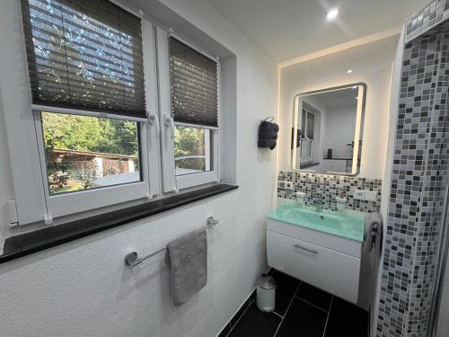 a bathroom with a sink and a mirror at Ferienwohnung Frankenruhe in Strullendorf