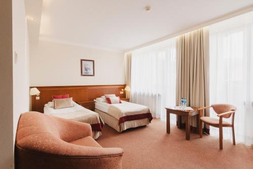 a hotel room with two beds and a couch at SPA Hotel Jawor in Jaworze