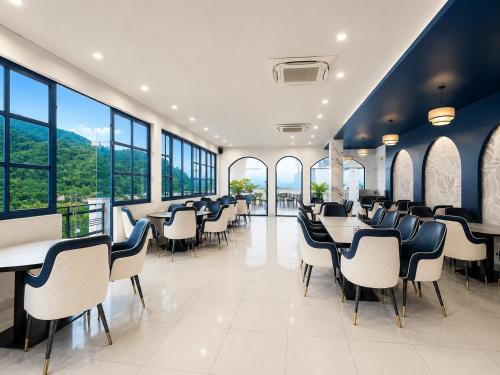 a restaurant with tables and chairs and large windows at Hotel Weekend Heights in Rishīkesh