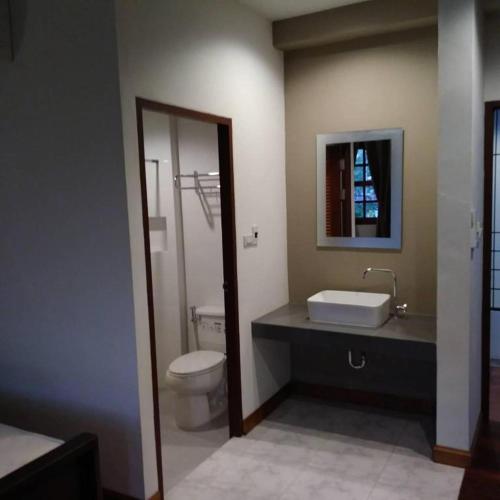 a bathroom with a white toilet and a sink at Phumin Place Hotel in Nan