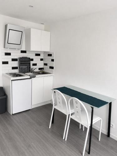 a kitchen with a table and two chairs at Violette 2 in La Souterraine