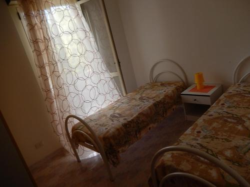 ガリポリにあるAppartamento Lybraの窓付きの小さな部屋のベッド2台