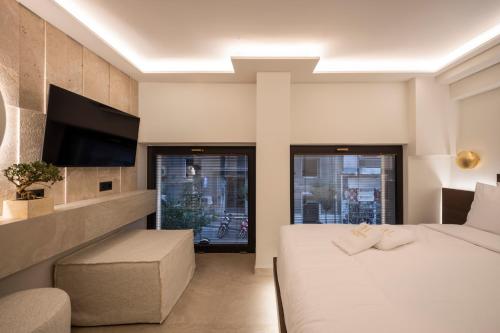 a hotel room with a bed and a tv at Anthem Suites & Spa in Athens