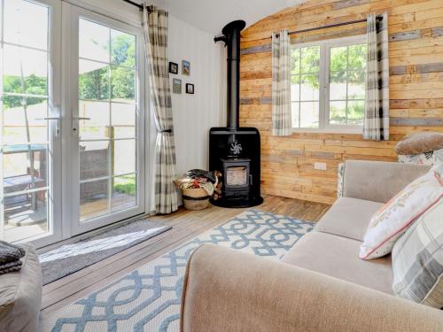 a living room with a couch and a stove at Hoy Haven in Whitwell