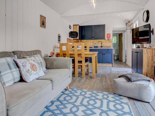 a living room with a couch and a kitchen at Hoy Haven in Whitwell
