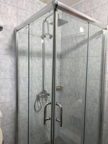 a shower with a glass door in a bathroom at MakerereViewAirbnb in Kampala