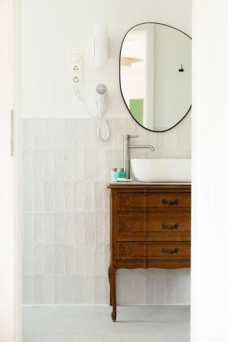 a bathroom with a sink and a mirror at Macskalépcsős Boutique B&B in Dörgicse